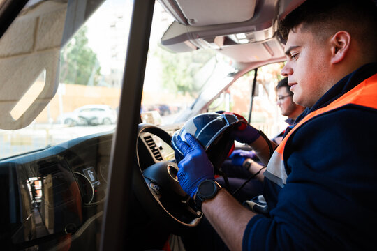 Paramedics preparing helmet inside ambulance for emergency