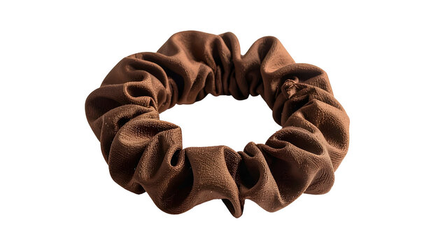 A close-up studio shot of a brown, fabric scrunchie with a black background