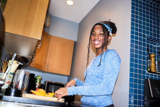 Smiling teen cutting mango