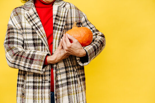Anonymous Woman in Plaid Coat Holding Pumpkin 