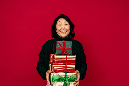 Senior Woman with Stack of Christmas Gifts