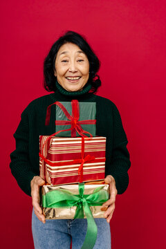 Happy Woman Holding Stack of Christmas Presents