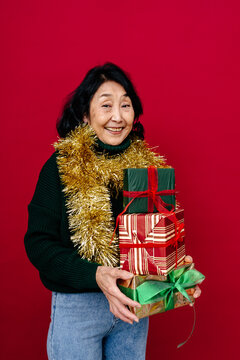 Smiling Woman Holding Christmas Presents with Gold Tinsel Scarf