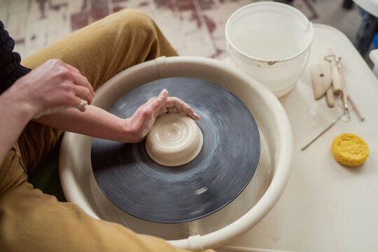 Hands Shaping Clay on Spinning Pottery Wheel  

