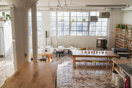 Bright pottery studio with tables and wheels  
