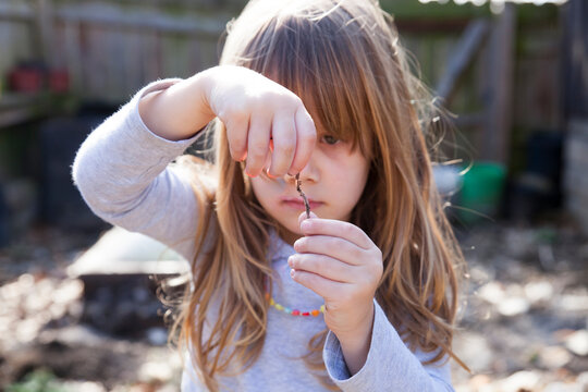Young girl with a worm she found
