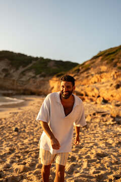 A man smiling big as he walk to the camera