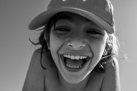 A boy smiling on a close up photo in black and white