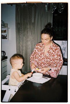 Toddler enjoying a playful moment while cooking with mother 
