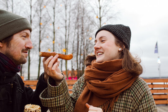 The couple eat one churro stick between them and laugh.