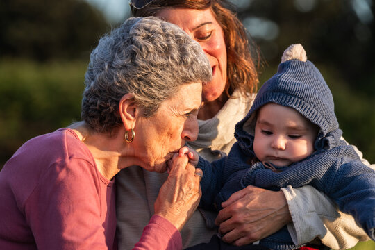 Grandmother kissing hand of her grandson 
