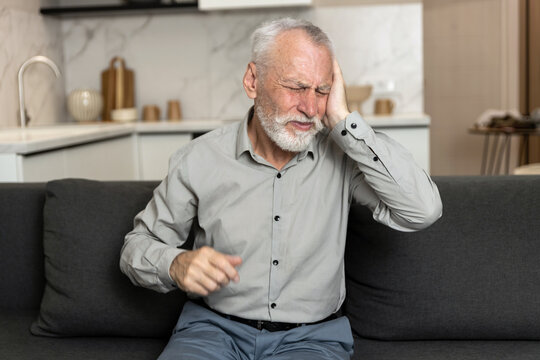 Senior man holding head with pain, feel migraine and ear infection
