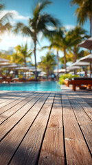 Fototapeta premium Wooden poolside terrace with tropical resort pool as backdrop, sun loungers and palm trees, sunny weather, relaxing summer vibes. Vertical image