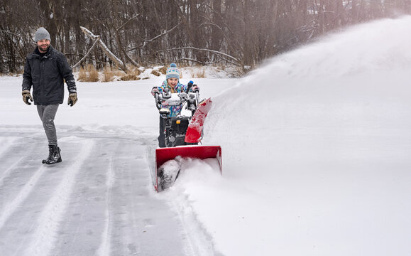 Father and daughter snow blowing ice rink together