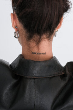 Woman showcases stylish leather jacket and tattoo
