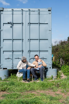 Family enjoying time together in front of their container house
