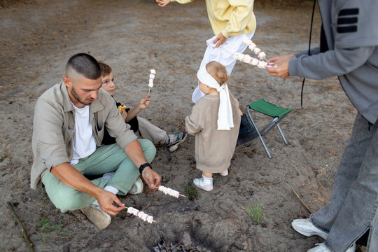 the family cooks marshmallows on the fire