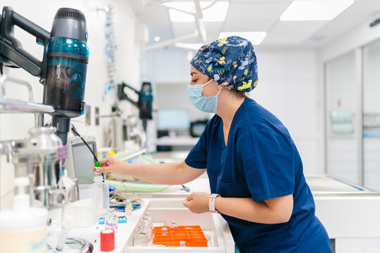 Veterinarian preparing equipment for surgery in operating room