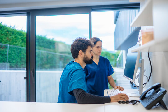 Healthcare professionals working on computer in modern clinic