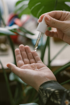 Woman Dispensing Facial Oil into Her Palm