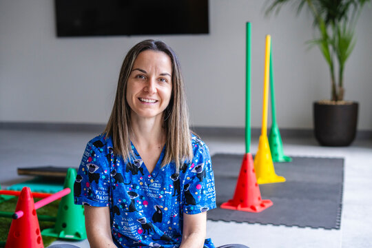 Veterinarian smiling in a rehabilitation room with colorful cones