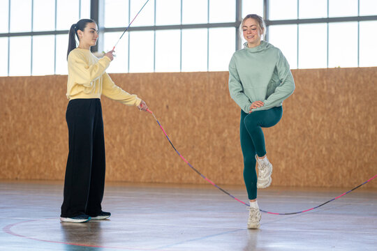 Sportswear girls exercising jumping with skip rope