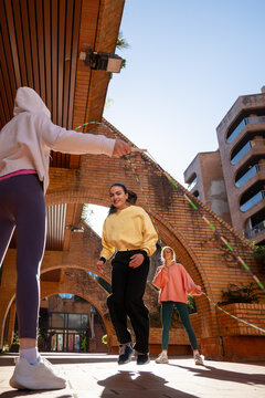 Brunette girl jumping rope with best friends 
