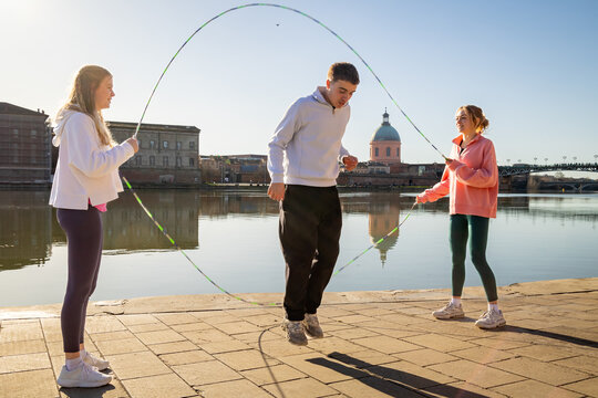 Group of Teenager Friends having fun playing double dutch by the River