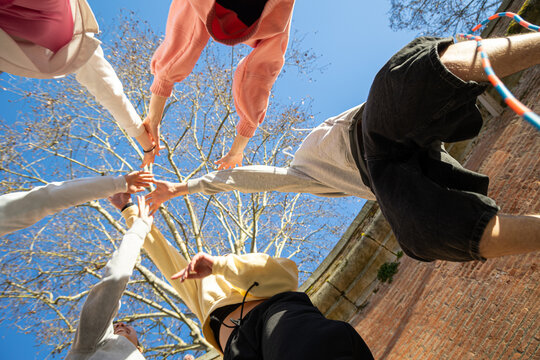 Teens Hands Together in Sunny Blue Sky