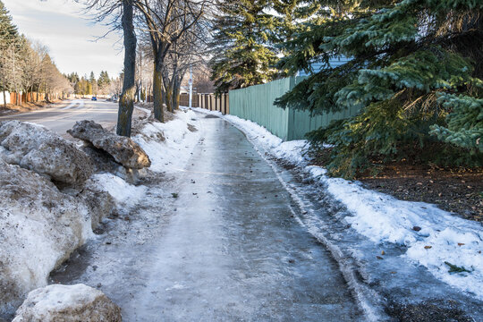 Icy sidewalk due to thaw in winter season