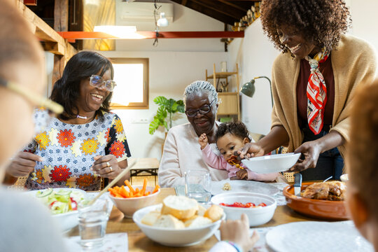Happy family having lunch together at home dining room laughing 