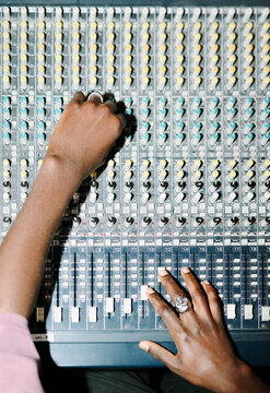 Close-Up of Hands Working on Soundboard