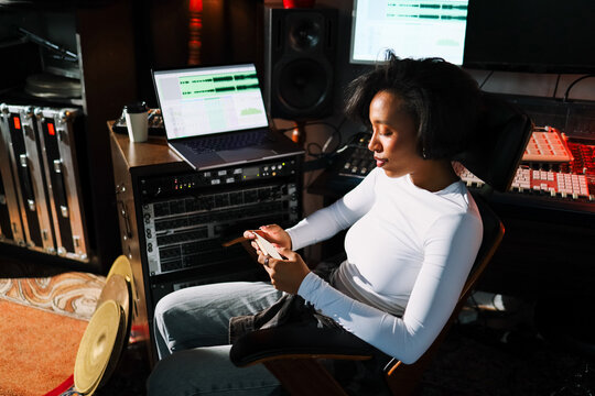 Woman Musician Checking Phone in Studio