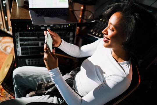 Joyful Music Creator Using Phone in Recording Studio