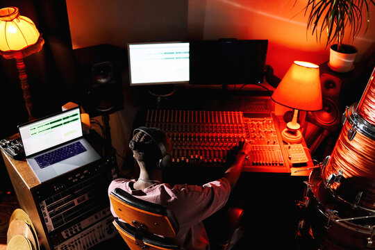 Man Working on Music Production at Night in Red Low Light