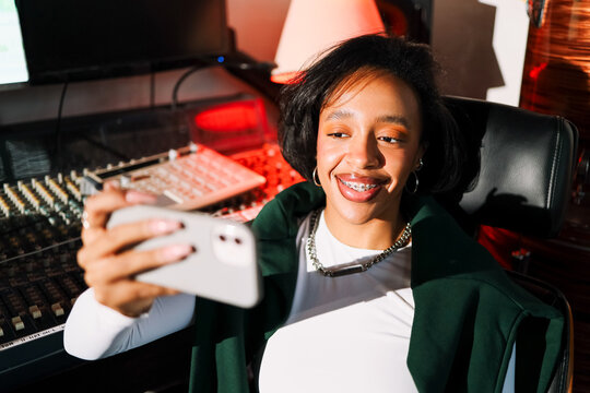 Smiling Woman Taking a Selfie in Studio