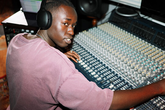 Man Mixing Audio Tracks on Soundboard