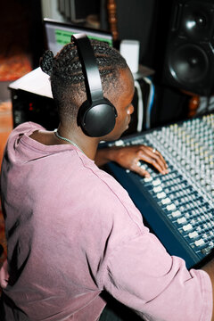 Sound Engineer Working on Mixing Console with Headphones