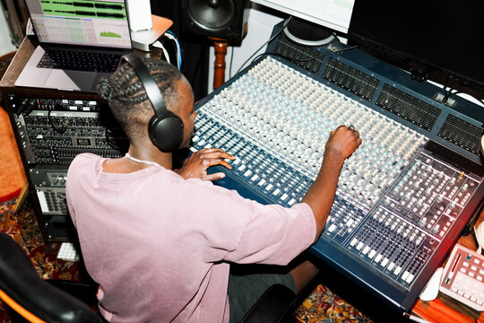 Music Producer Adjusting Sound Mixer in Studio