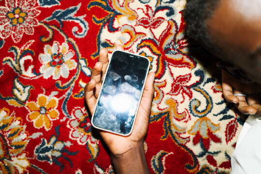 Hand holding phone with smudged screen