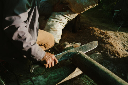 Farmer chopping wood with machete in the farm