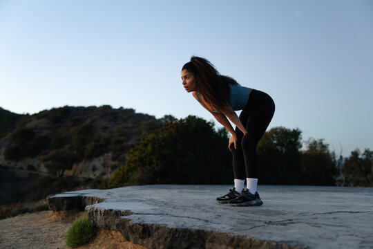 Focused Female Athlete Resting During Outdoor Workout