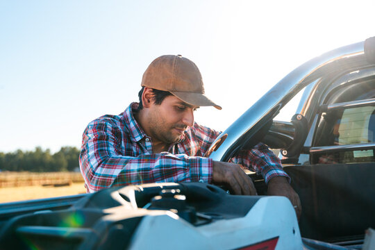 Latin farmer putting equipment in his pickup truck