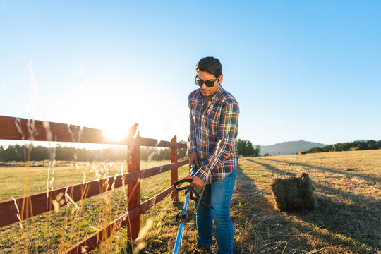 Farmer man using brush cutter in farm 