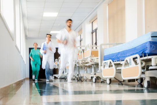 Medical team running in hospital corridor to emergency room