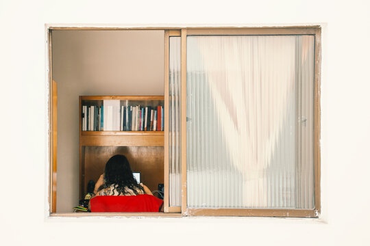 Portrait through window of woman doing home office