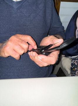 Senior Citizen using vintage flip phone dial