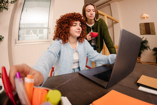 Wide shot of an employee taking a bookmark while working with a laptop