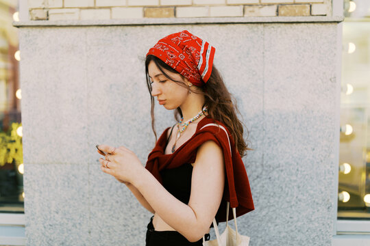 Portrait of young brunette woman on the phone outdoors
