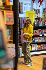 Young woman browsing books at bookstore table